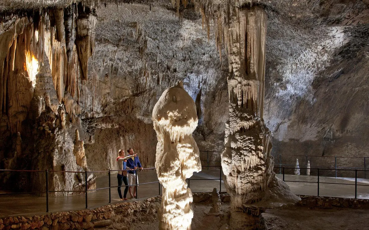 A lit walkway running through a passage deep inside the cave at Postojna