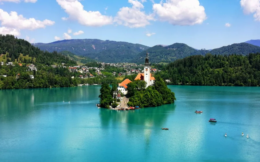 Lake Bled from the air, turquoise water around the wooded island with its church